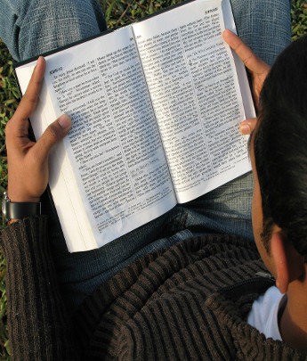 ▲ 들판에 앉아 성경을 읽고 있는 그리스도인